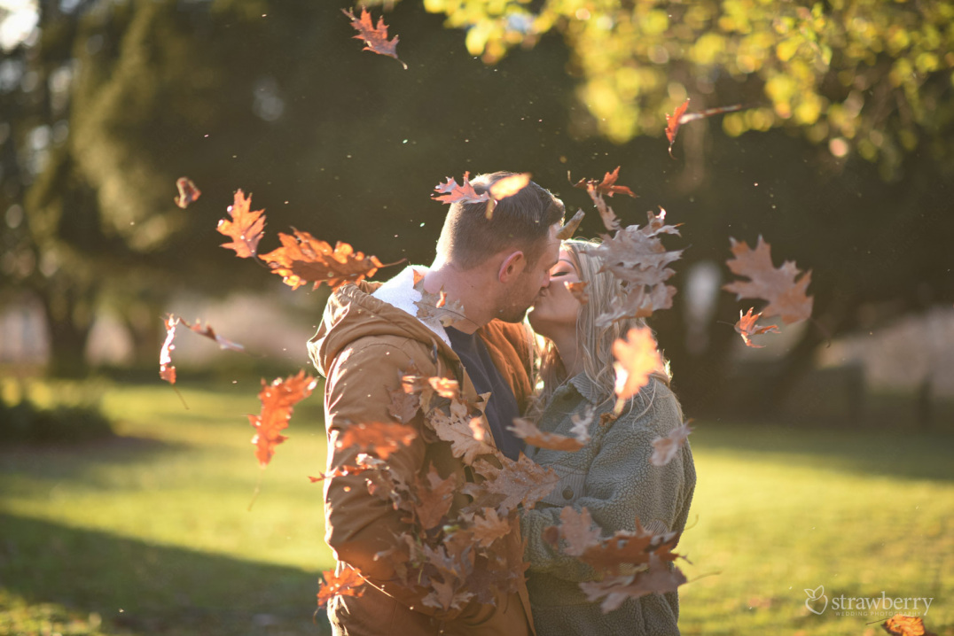 couple-kissing-in-park-autumn-leaves-1