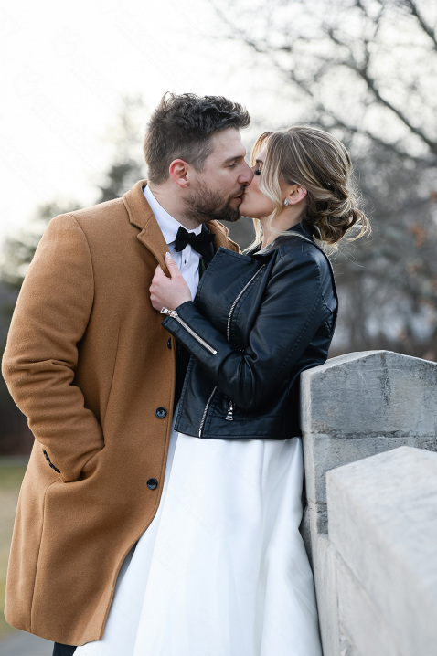 22-newlyweds-kissing-wedding-brown-coat