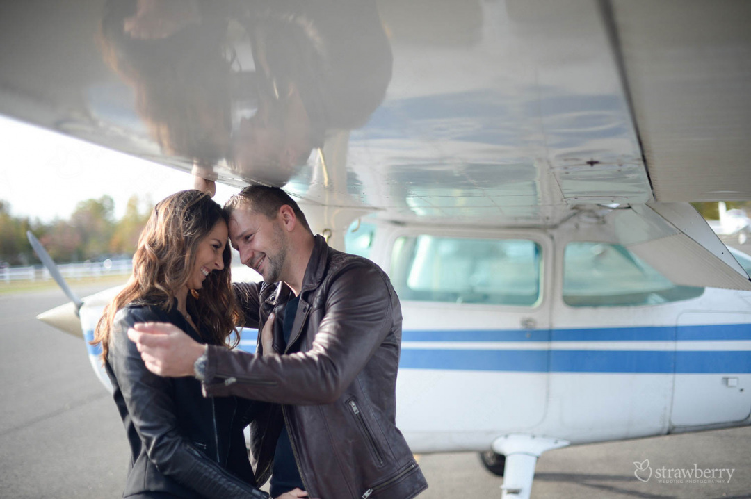 happy-engaged-couple-under-plane-wings