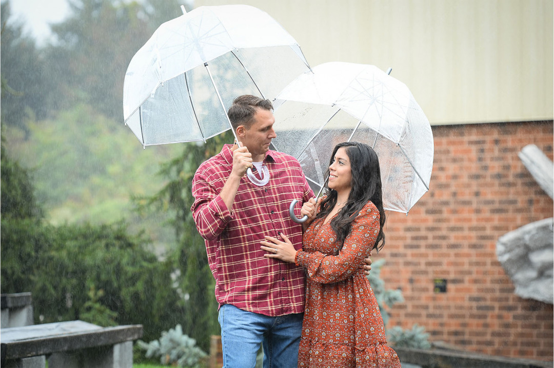 6-engaged-couple-under-umbrellas-smile